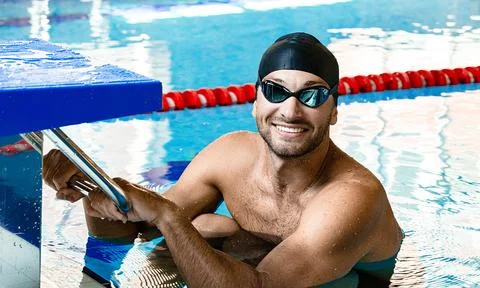 Man swimmer getting ready to start swimming in a swimming pool. Professional  库存照片