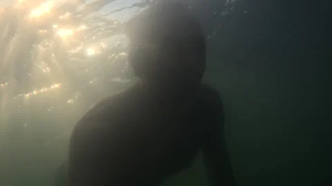 Man swimming and diving in clear blue water, enjoying summer vacation and Stock Footage 343441300