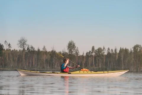 A man is swimming in a kayak. Side view. Stock Photos