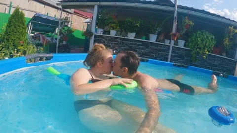 Man swimming in a pool between inflatable children. View from above Stock Footage 241900912