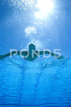 Man in swimming pool, portrait, underwater view (lens flare) Stock Photos