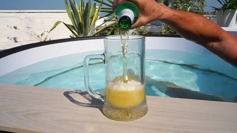 Man in a swimming pool pours beer heat,refreshing. Beer festival oktoberfest Stock Footage 279986038
