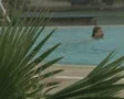 Man swimming in pool in rain SD Footage