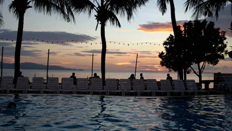 A man is swimming in the pool at sunset Stock Footage 91808252