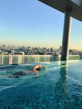 Man swimming in rooftop pool on skyscraper, Singapore, South East Asia Stock Photos
