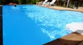 Man Swims Back in Private Outdoor Swimming Pool near Luxury Villa. HD Footage