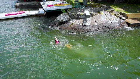 Man swims to dock Stock Footage 135691288