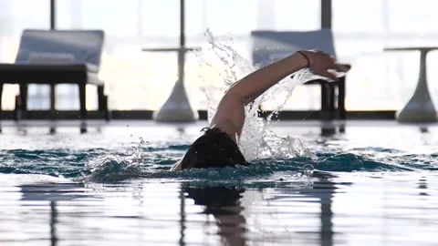 Man swims in the hotel pool on the background of loungers Stock Footage 91977239