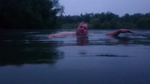 Man swims at night in the river Stock Footage 65841075
