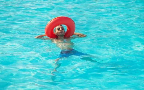 Man swims in a pool with a circle. Selective focus. Stock Photos