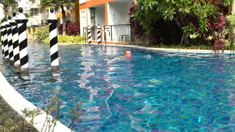 Man swims in the pool in hotel Stock Footage 91560682