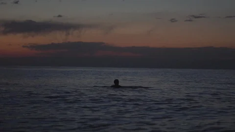 A man swims at sunset Stock Footage 94703986
