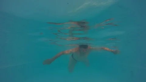 Man swims under water on camera slow motion Stock Footage 103301507