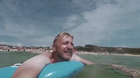 A man swims on the waves of the sea on an inflatable circle Video stock 162516638