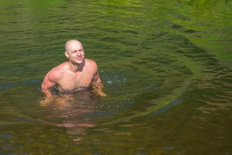 A man swims in a wild river with the current. Adventure traveling lifestyle Stock Photos