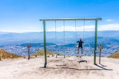 Man on a swing at a viewpoint in the mountains Stock-Fotos