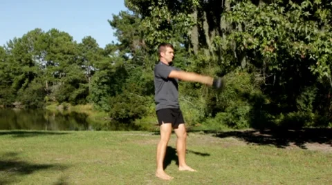 Man swinging a kettlebell in the park Stock Footage 8778183