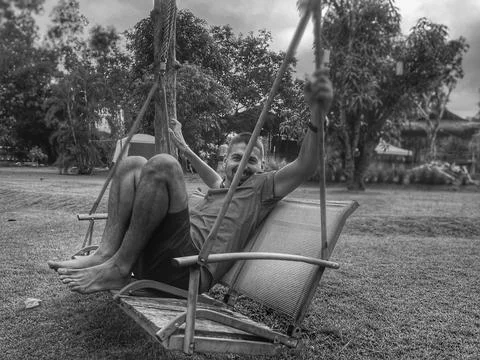 Man swinging on swing in back yard Stock Photos