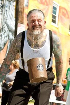 Man Swings Bucket Of Bricks Using Eyelids In Freak Show Fotos de archivo