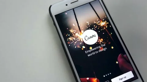 A man swiping Canva app on iPhone Stock Footage 138937414