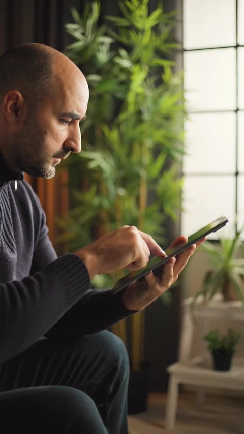 Man Swiping Vertical Tablet Screen at Desk Stock Footage 346810054