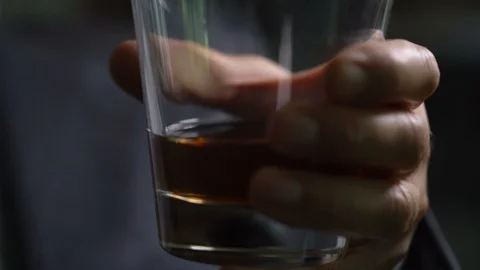 Man Swirling Whiskey or Bourbon in Glass Stock Footage 112636768