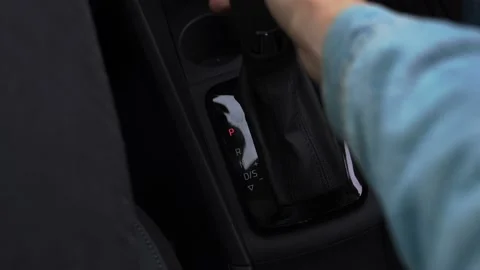 A man switches the automatic transmission on a new car in a car dealership Stock Footage 140962384