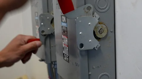 A man switches on an electrical breaker. Stock Footage 99597672