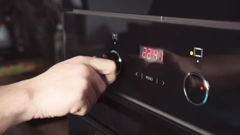 Man switches modes on the oven panel, close up. A man's hand turning the handle Stock Footage 164122387