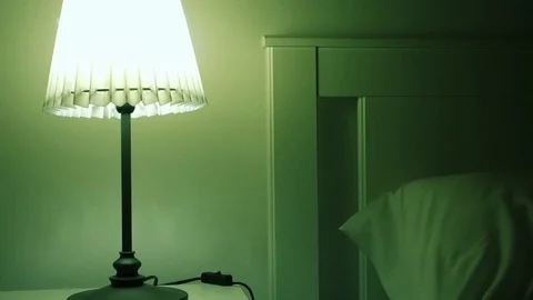 Man switching off a bedside table light before sleeping Stock Footage 126844748