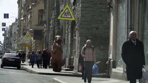 Man in t rex costume in crowd of people walking on city sidewalk Stock Footage 84929798