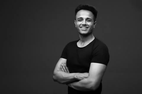 A Man In A T-Shirt Is Posing For The Camera With Crossed Arms Stock Photos