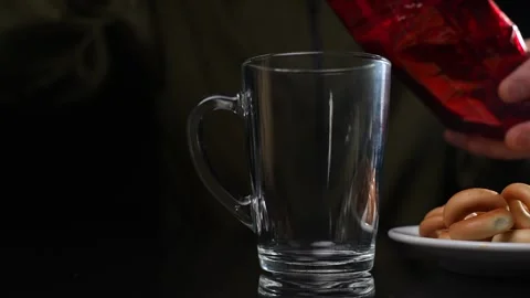 A man at a table with bagels brews black tea. Slow motion Video stock 249188017
