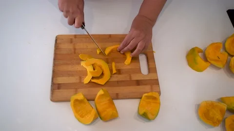 A man on the table cleans and cuts a pumpkin Stock Footage 238627151