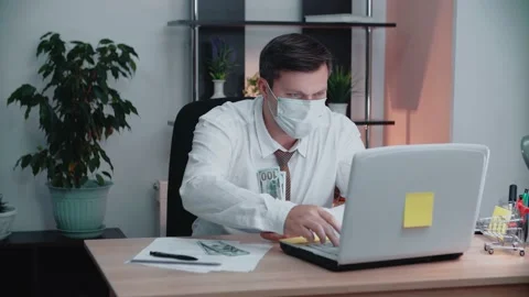 The man at the table is counting the money.A man in a protective mask. Stock Footage 146264164