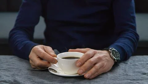 A man at the table with a cup of coffee. Selective focus. Foto stock