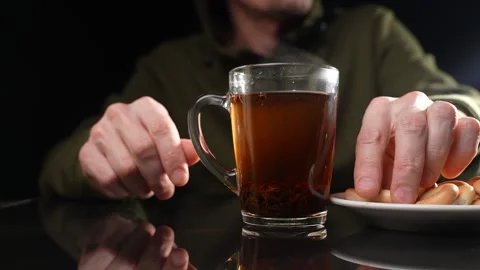 A man at the table drinks tea with bagels. Slow motion Video stock 249229106