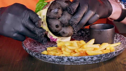 A man at a table is eating a burger. Stock-Footage 311261366