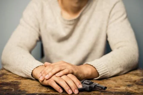 Man at table with a gun Stock Photos