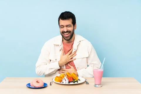 Man at a table having breakfast waffles and a milkshake smiling a lot Stock Photos