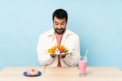 Man at a table having breakfast waffles and a milkshake Stock Photos
