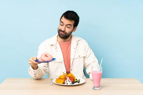 Man at a table having breakfast waffles and a milkshake Stock Photos