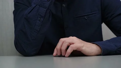 Man at the table taps his fingers thoughtfully on table. waiting. hand gesture. Video stock 220917319