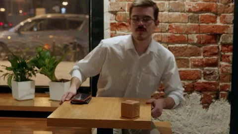 Man at table with wooden cube and phone 库存影片 342779549
