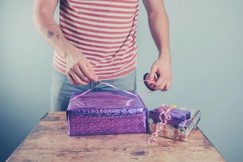 Man at table wrapping presents Stock Photos