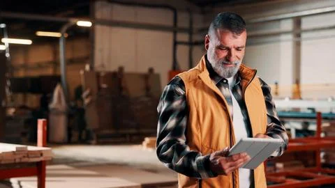 Man, tablet and scroll in carpentry workshop, check lumber order or online .. Stock Photos
