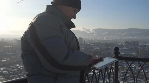Man with tablet computer on the background of the urban landscape in winter Stock Footage 61179101