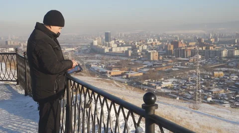 Man with tablet computer on the background of the urban landscape in winter Stock Footage 61179639
