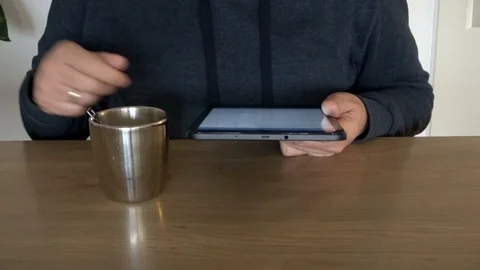 Man On Tablet Computer Checking Mail And Stirring Morning Coffee 스톡 동영상 99985640