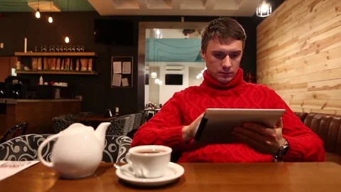 Man with tablet computer drinking tea in cafe Vídeo Stock 71835121